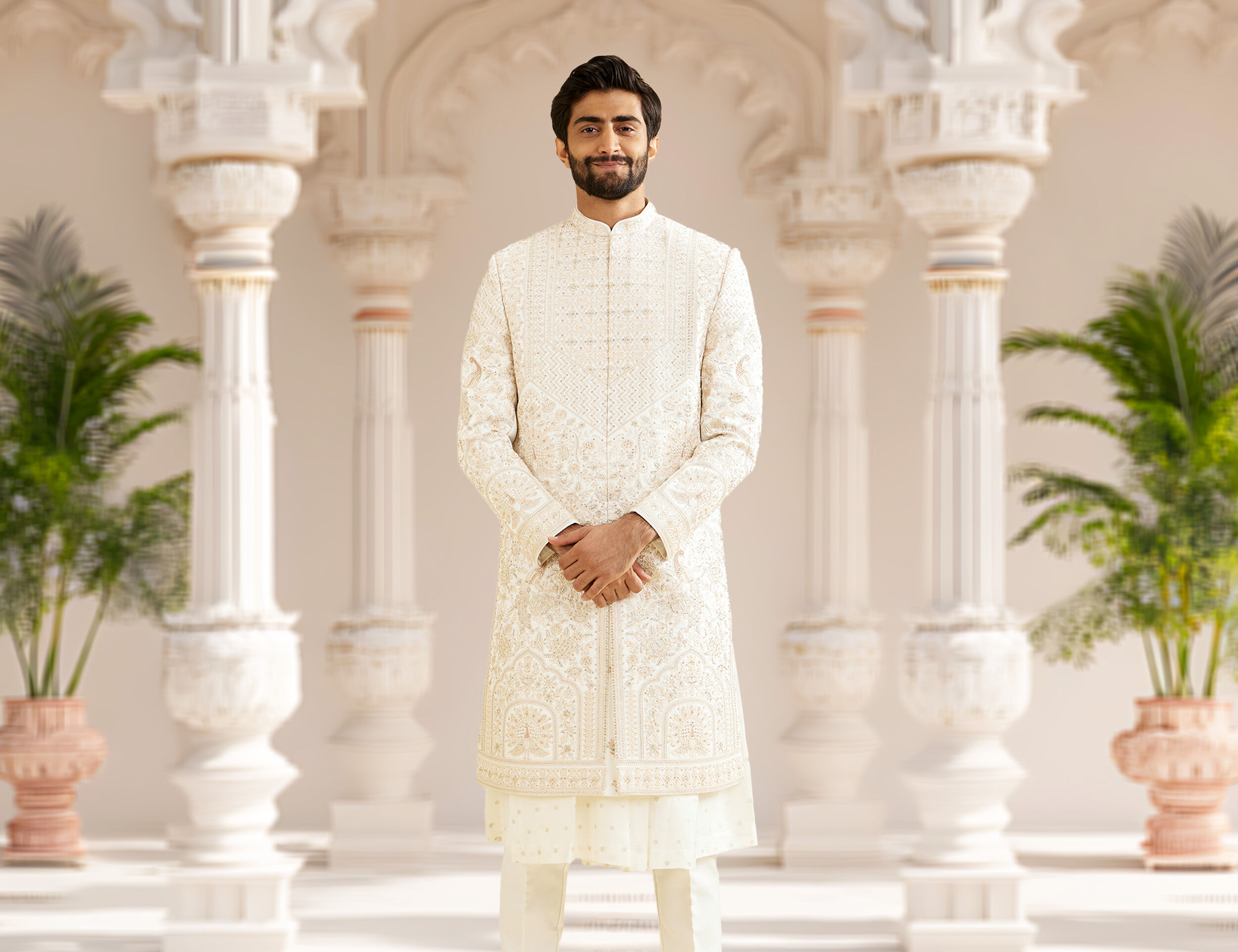 A groom in white sherwani on wedding